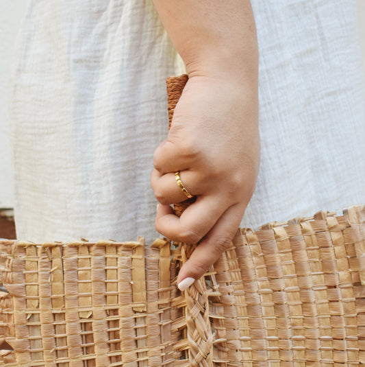 18k gold vermeil ring holding polynesian woven bark hand fan